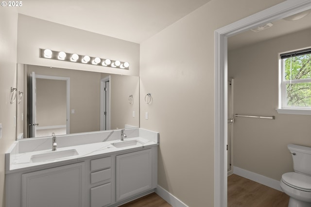 111 SE 49th Ct, Hillsboro, OR 97123 - bathroom with toilet, wood finished floors, double vanity, and baseboards