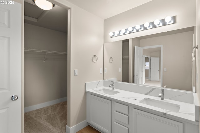 111 SE 49th Ct, Hillsboro, OR 97123 - bathroom featuring a walk in closet, double vanity, and baseboards