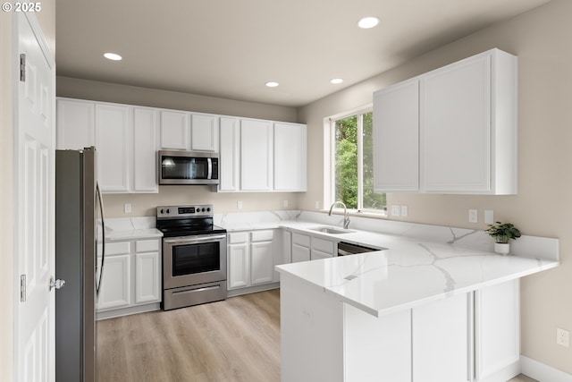 111 SE 49th Ct, Hillsboro, OR 97123 - kitchen with appliances with stainless steel finishes, a peninsula, a sink, light wood-type flooring, and recessed lighting