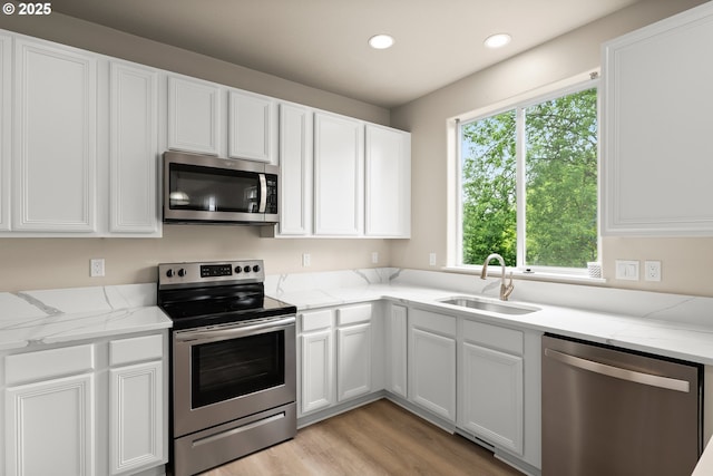 111 SE 49th Ct, Hillsboro, OR 97123 - kitchen featuring stainless steel appliances, a sink, white cabinetry, recessed lighting, and light wood-style flooring
