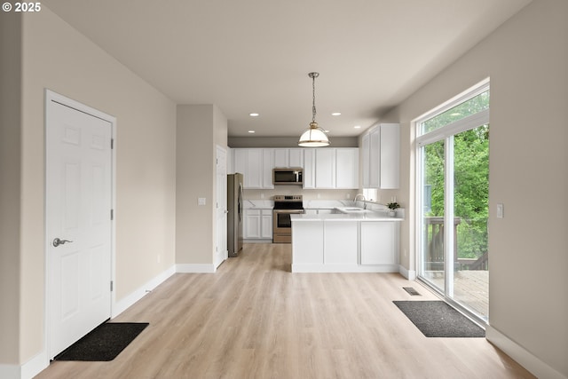 111 SE 49th Ct, Hillsboro, OR 97123 - kitchen with appliances with stainless steel finishes, light wood-style floors, baseboards, white cabinetry, and a sink