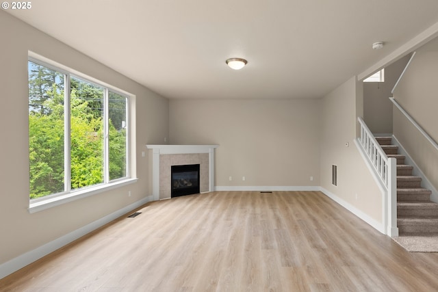 111 SE 49th Ct, Hillsboro, OR 97123 - unfurnished living room featuring plenty of natural light, light wood-style flooring, stairs, and baseboards