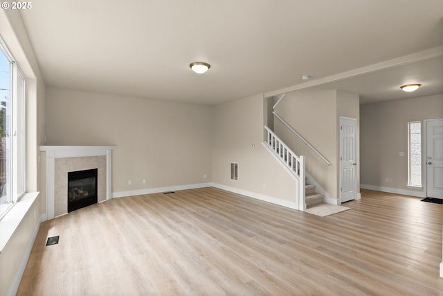 111 SE 49th Ct, Hillsboro, OR 97123 - unfurnished living room with light wood finished floors, stairs, baseboards, and a fireplace