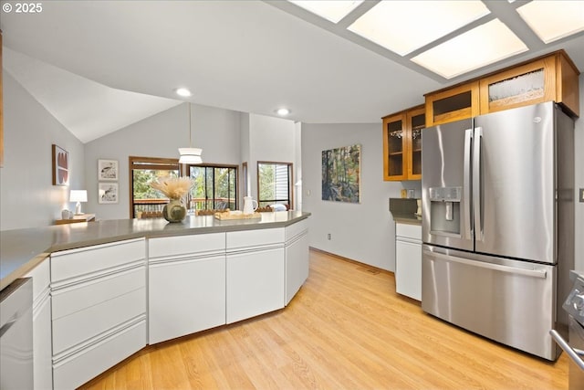 kitchen with vaulted ceiling, stainless steel fridge with ice dispenser, dishwasher, light hardwood / wood-style floors, and white cabinets