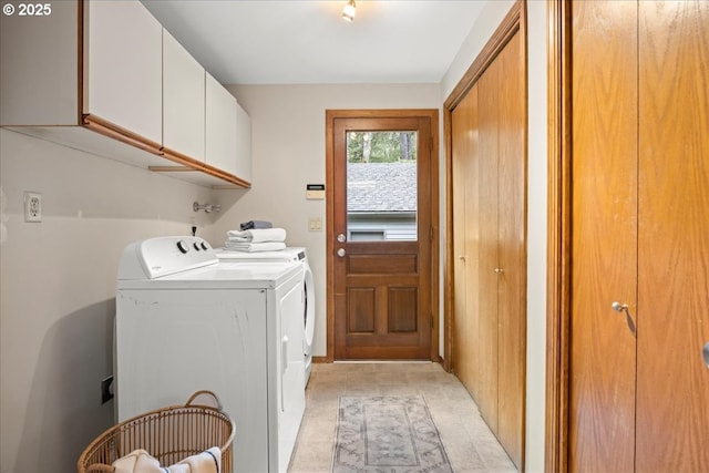 clothes washing area featuring cabinets and washing machine and dryer