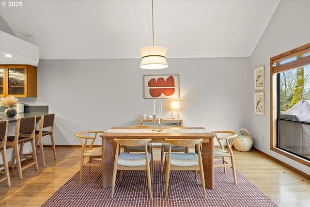 dining room featuring vaulted ceiling and light wood-type flooring