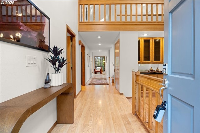 entryway featuring a towering ceiling and light wood-type flooring