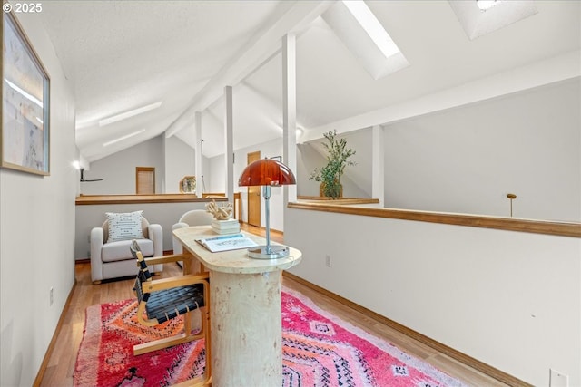 interior space featuring light hardwood / wood-style floors and vaulted ceiling with skylight