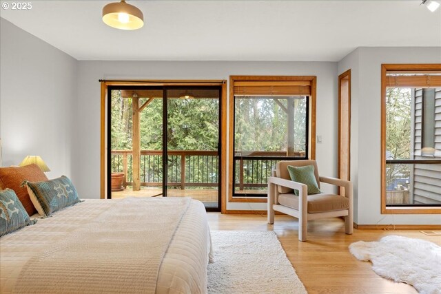 bedroom featuring access to exterior and light hardwood / wood-style flooring