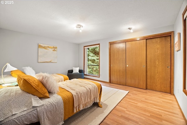 bedroom with light hardwood / wood-style flooring, a closet, and a textured ceiling