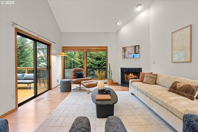 living room featuring high vaulted ceiling and light wood-type flooring