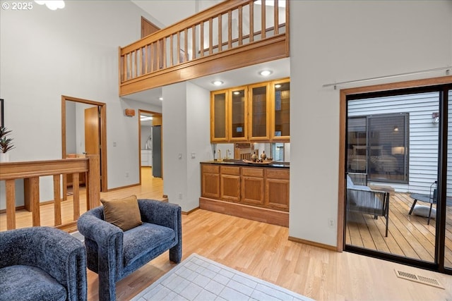 living room with a towering ceiling and light hardwood / wood-style floors