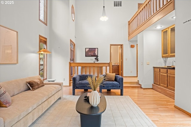 living room featuring a towering ceiling and light hardwood / wood-style flooring