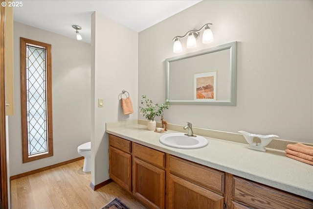 bathroom with vanity, wood-type flooring, and toilet