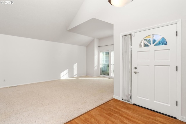 foyer featuring vaulted ceiling and wood-type flooring