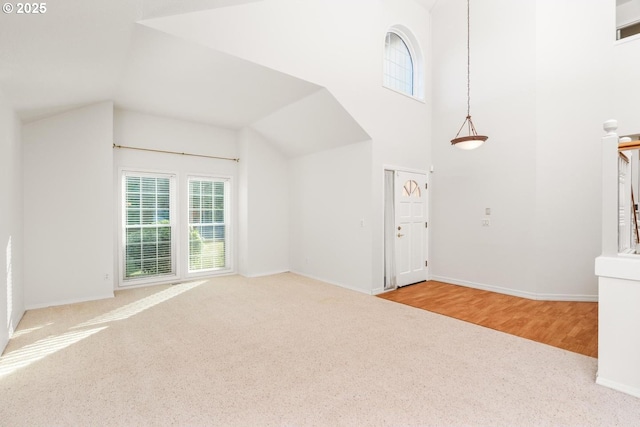 interior space featuring high vaulted ceiling and light carpet