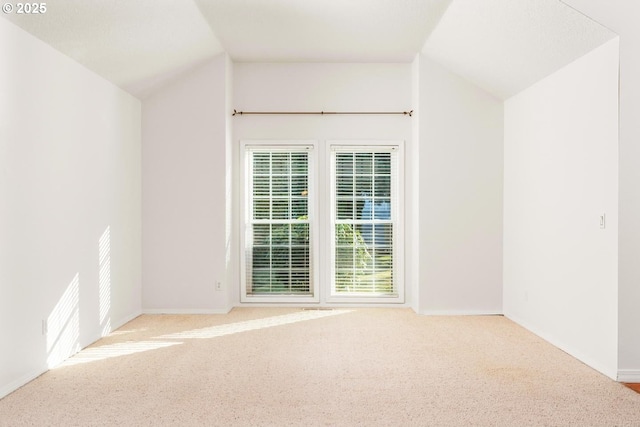 bonus room with lofted ceiling and light colored carpet