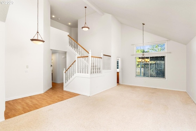 unfurnished living room featuring beamed ceiling, carpet floors, a notable chandelier, and high vaulted ceiling