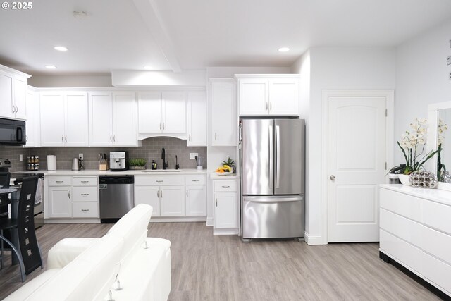 4604 NE 119th St, Vancouver, WA 98686 - kitchen with light wood-type flooring, white cabinets, appliances with stainless steel finishes, light countertops, and a sink