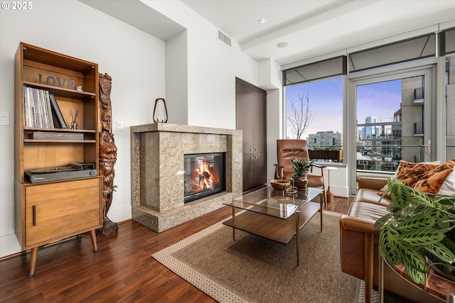 living room featuring visible vents, a view of city, a fireplace, dark wood-type flooring, and recessed lighting
