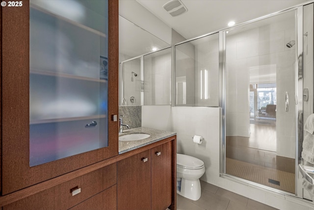 bathroom with vanity, tile patterned floors, a stall shower, and toilet