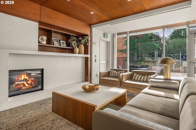 living area with recessed lighting, wood ceiling, a glass covered fireplace, and built in shelves