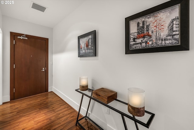 doorway to outside with visible vents, baseboards, and wood finished floors