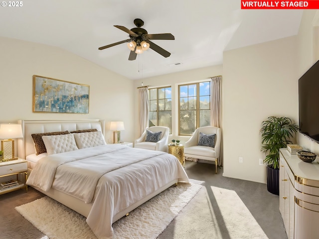 bedroom featuring lofted ceiling, dark carpet, and ceiling fan