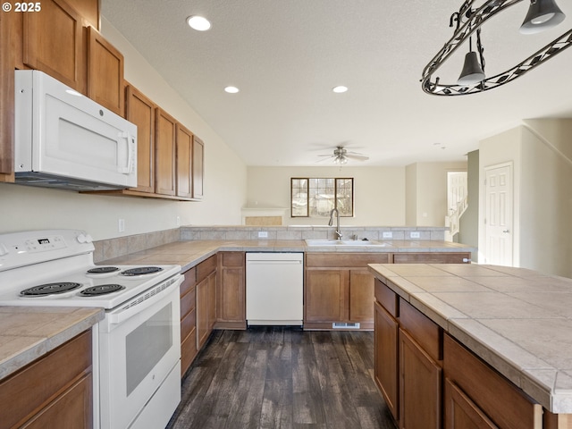 kitchen with dark hardwood / wood-style floors, tile countertops, sink, ceiling fan, and white appliances