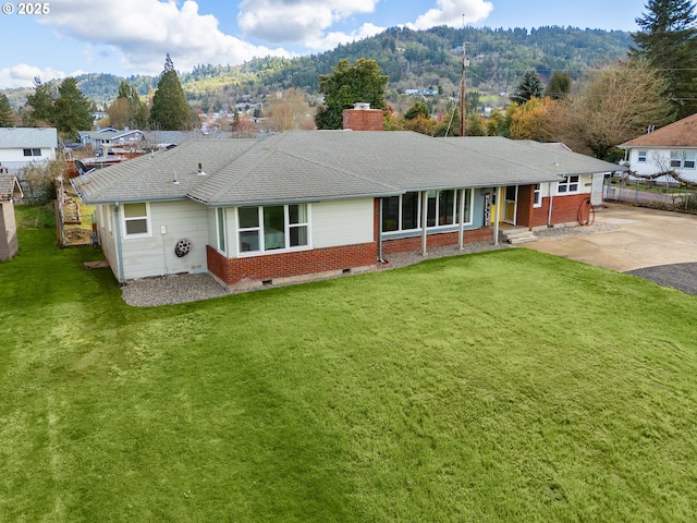 view of front facade featuring crawl space, a chimney, a front lawn, and brick siding