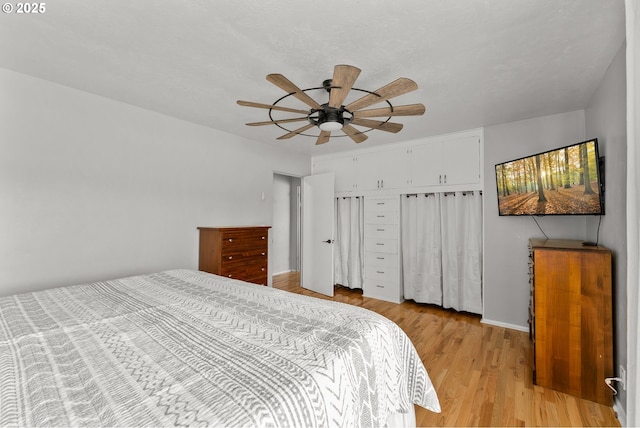 bedroom featuring light wood finished floors, a closet, and a ceiling fan