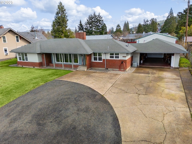 ranch-style home with concrete driveway, a front lawn, a chimney, and crawl space