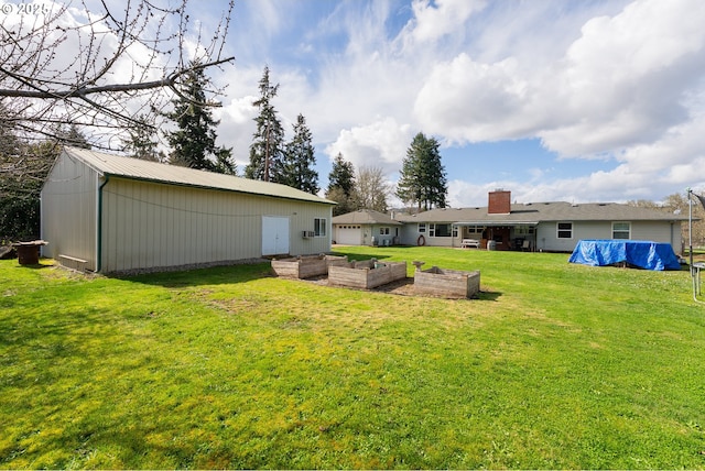 view of yard featuring a vegetable garden, an outbuilding, and an outdoor structure