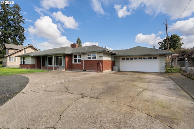 ranch-style house featuring a garage, brick siding, fence, concrete driveway, and a chimney