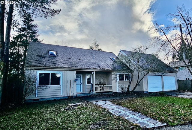 view of front of home featuring a garage, covered porch, and a front lawn