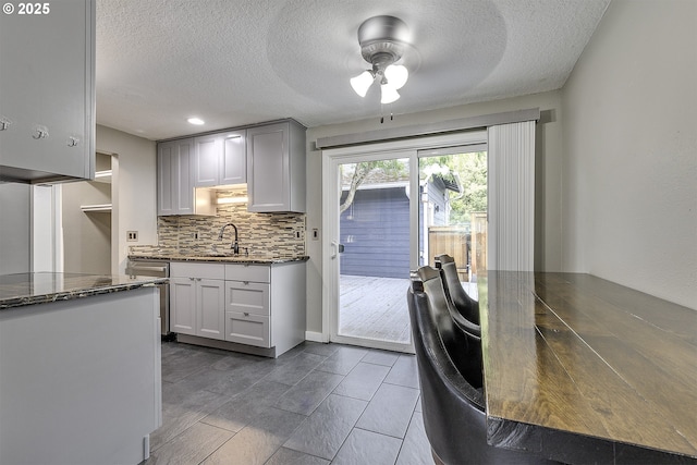 8396 SW Mohawk St, Tualatin, OR 97062 - kitchen featuring ceiling fan, decorative backsplash, dark stone counters, a textured ceiling, and recessed lighting