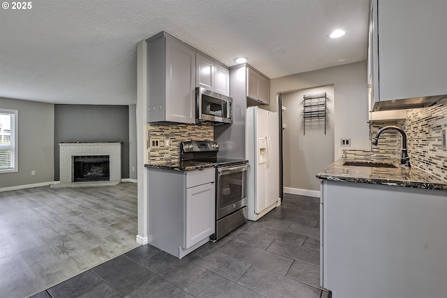 8396 SW Mohawk St, Tualatin, OR 97062 - kitchen featuring stainless steel appliances, dark stone counters, backsplash, open floor plan, and recessed lighting