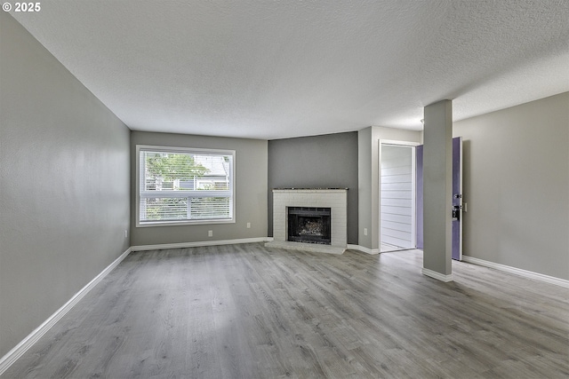 8396 SW Mohawk St, Tualatin, OR 97062 - unfurnished living room featuring wood finished floors, a brick fireplace, and a textured ceiling