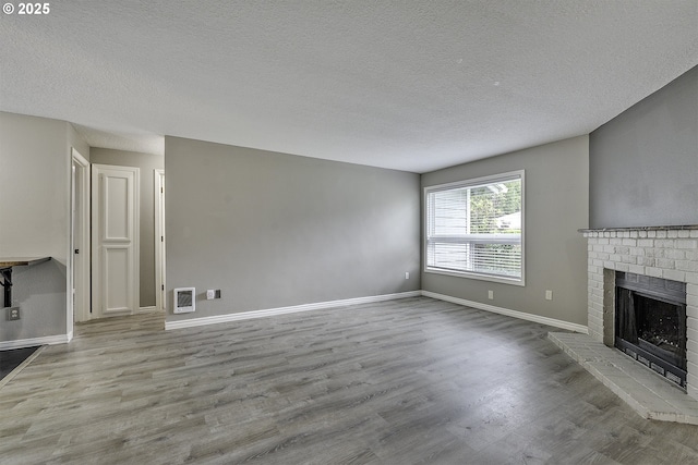 8396 SW Mohawk St, Tualatin, OR 97062 - unfurnished living room with wood finished floors, a textured ceiling, and a fireplace