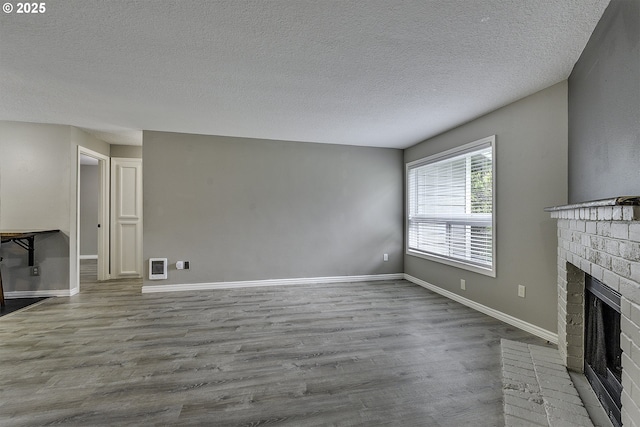 8396 SW Mohawk St, Tualatin, OR 97062 - unfurnished living room featuring wood finished floors, a fireplace, a textured ceiling, and heating unit