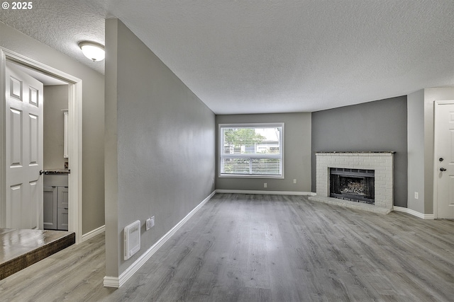 8396 SW Mohawk St, Tualatin, OR 97062 - unfurnished living room with a textured ceiling, wood finished floors, and a fireplace