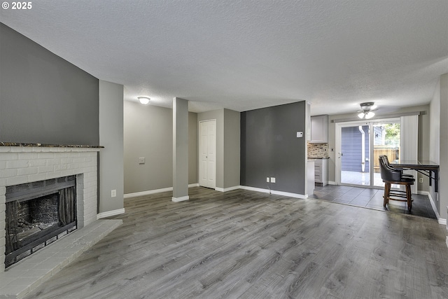 8396 SW Mohawk St, Tualatin, OR 97062 - unfurnished living room featuring a textured ceiling, wood finished floors, and a brick fireplace