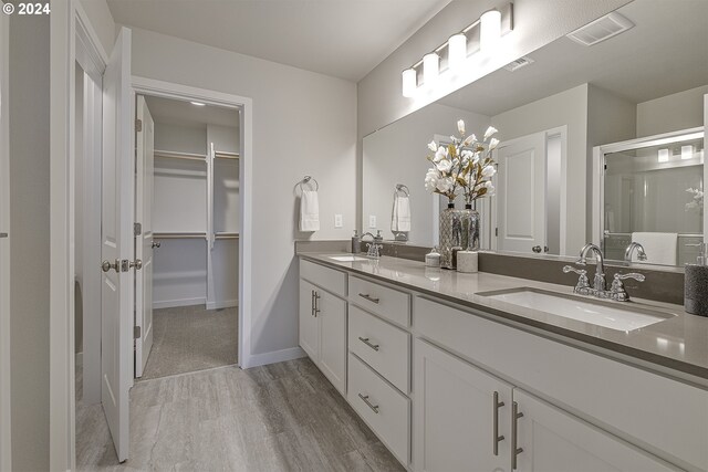 3610 Ash St Lot 17, Forest Grove, OR 97116 - bathroom with a spacious closet, wood finished floors, double vanity, a chandelier, and baseboards