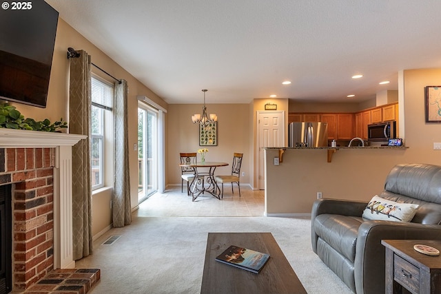 living area featuring light carpet, baseboards, visible vents, a fireplace, and recessed lighting