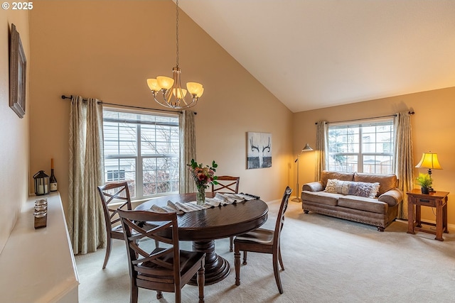 dining area featuring high vaulted ceiling, baseboards, a chandelier, and light colored carpet