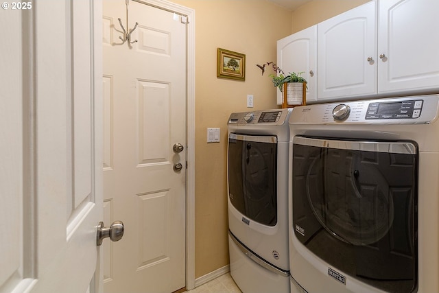 laundry room featuring cabinet space, washer and clothes dryer, and baseboards