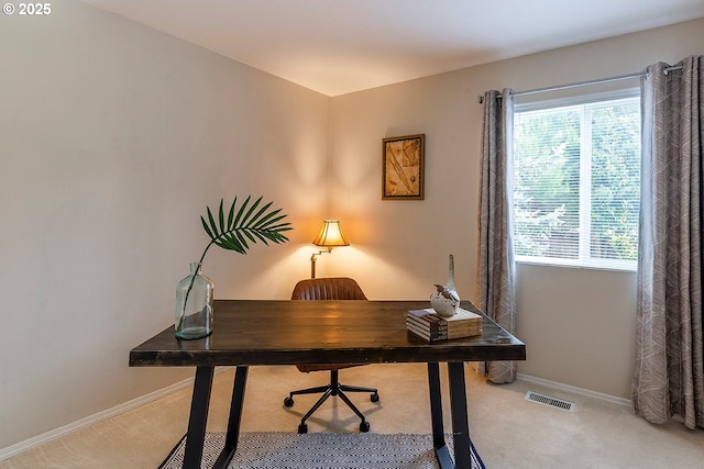 carpeted office featuring visible vents and baseboards