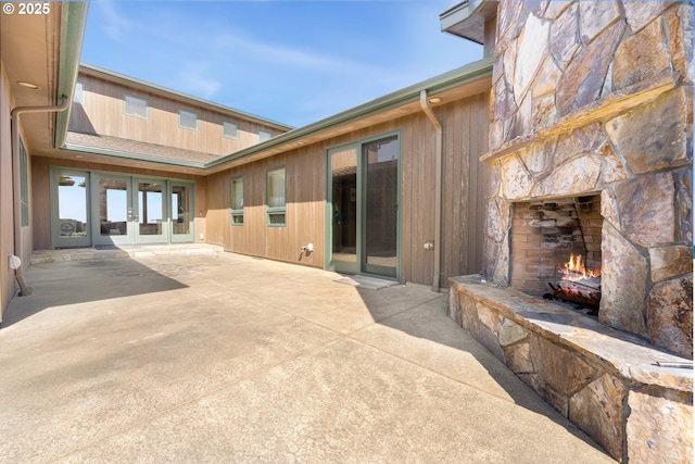 view of patio featuring an outdoor stone fireplace and french doors