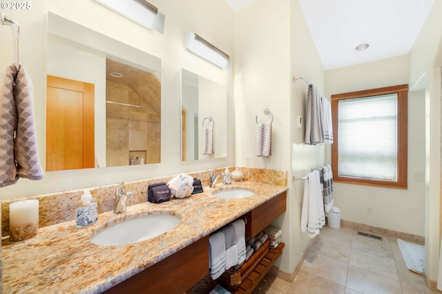 bathroom featuring tile patterned flooring, visible vents, a sink, and double vanity