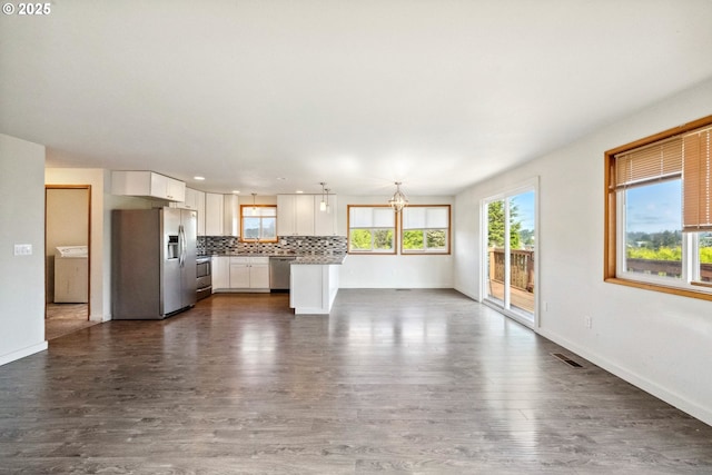 760 H St, Coos Bay, OR 97420 - unfurnished living room with washer / dryer, dark wood-style flooring, and baseboards